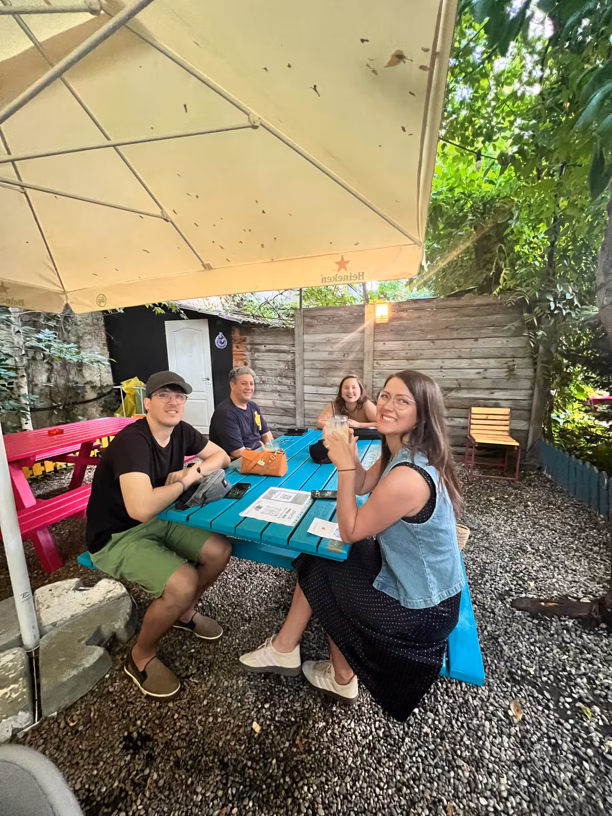 Members at a blue picnic table in a gravel garden