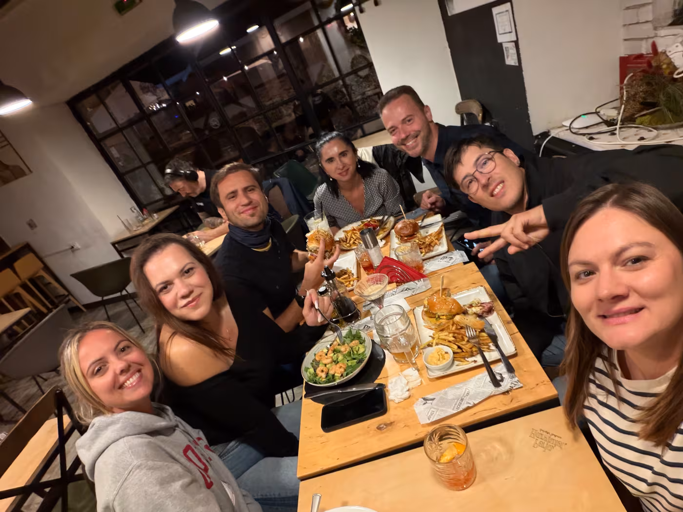 Group selfie over burgers and drinks at dinner