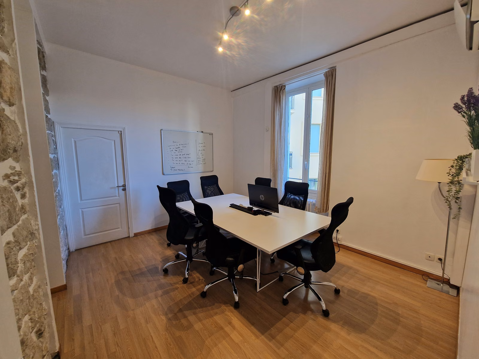 The meeting room, with a long white table and office chairs