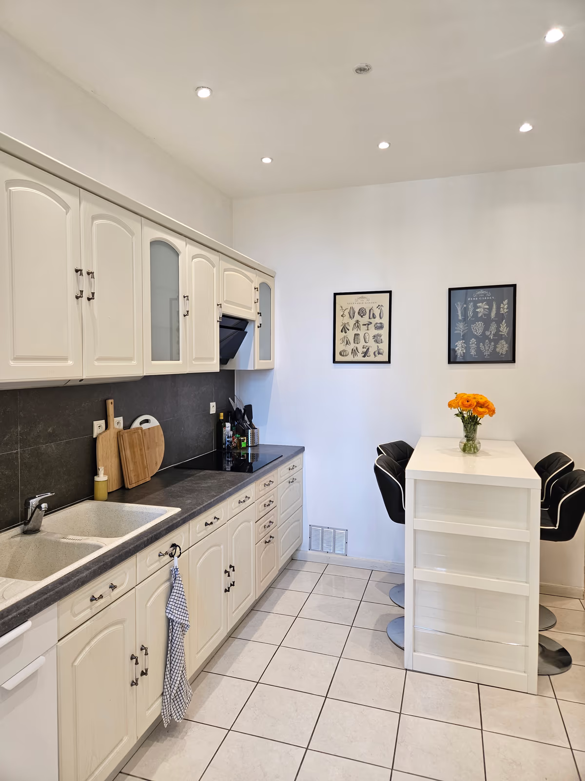 The kitchen worktop, with the sink, the hob and a long run of cream cabinets
