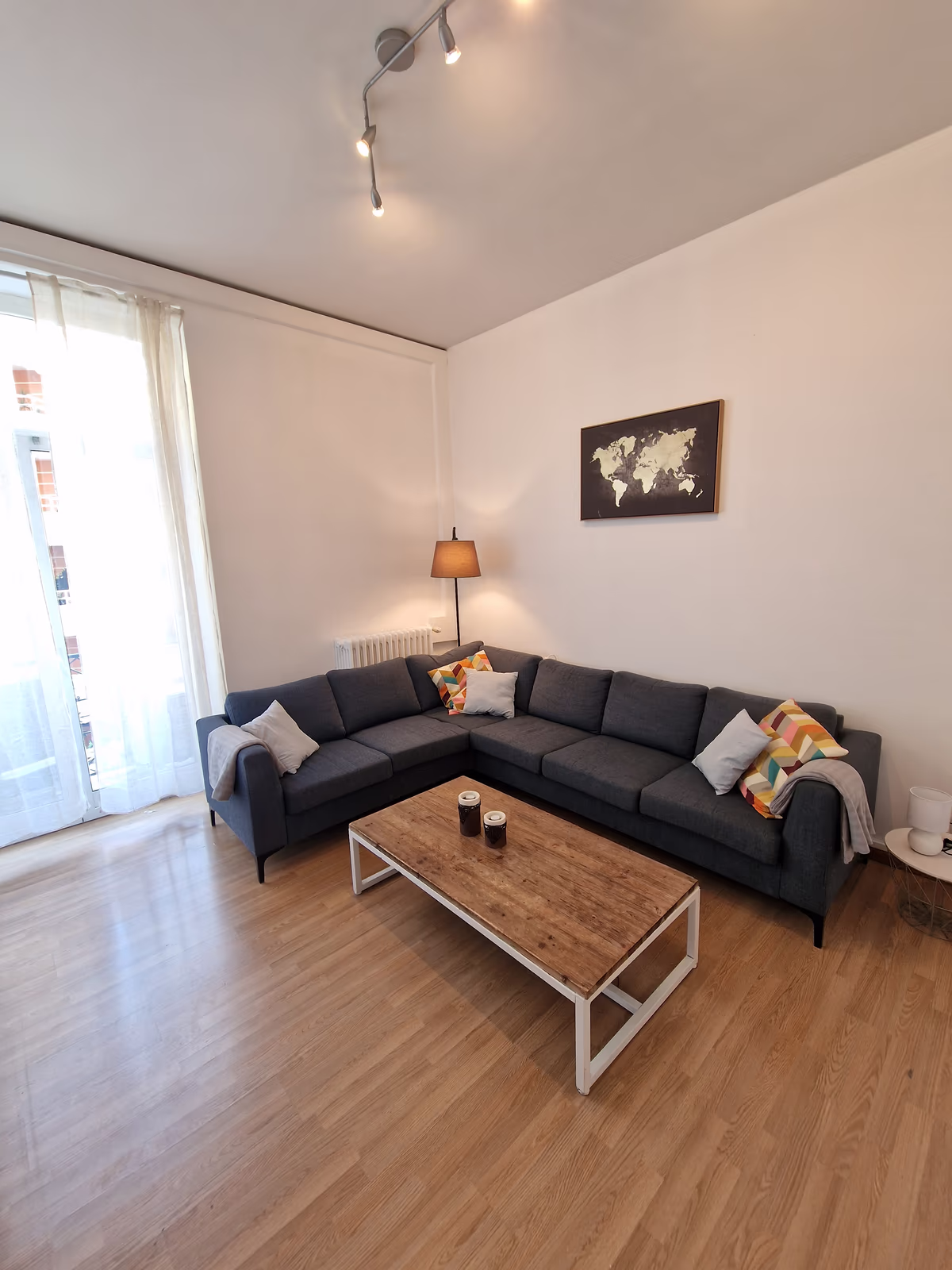 The living room of the NomadUnion apartment in Nice, with a corner sofa and a wooden coffee table