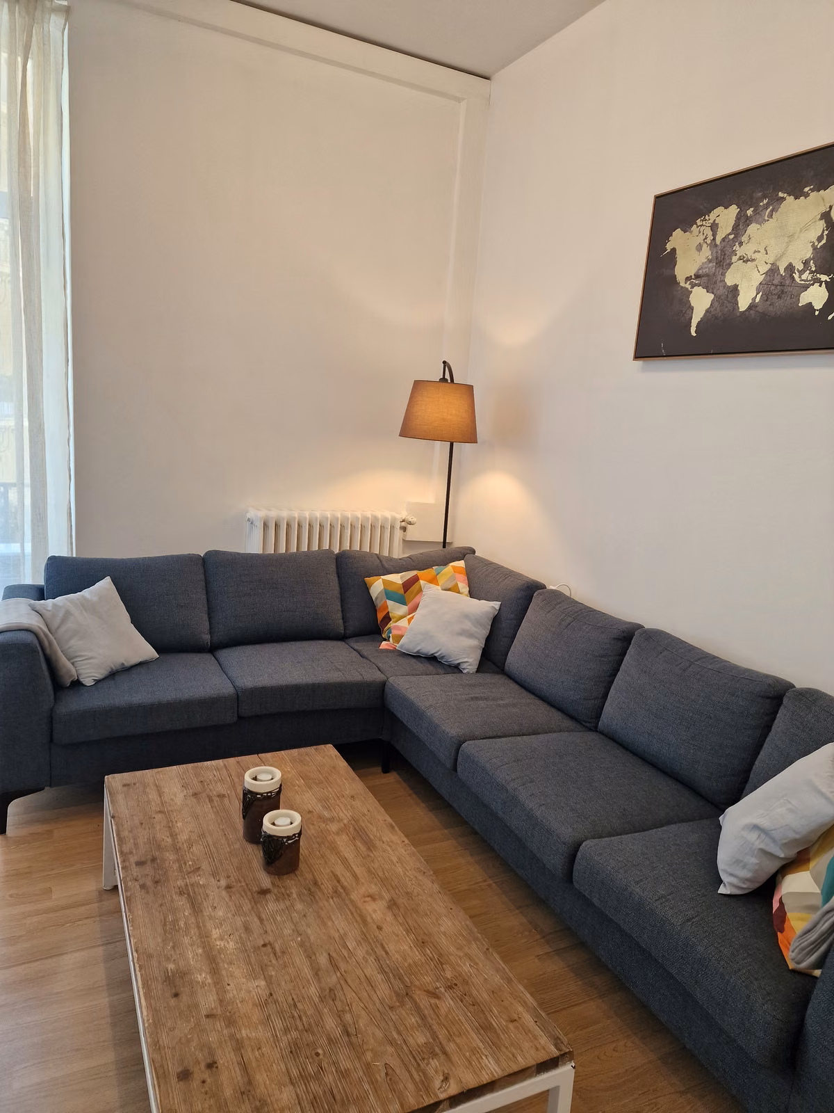 The living room with a corner sofa and a world map on the wall