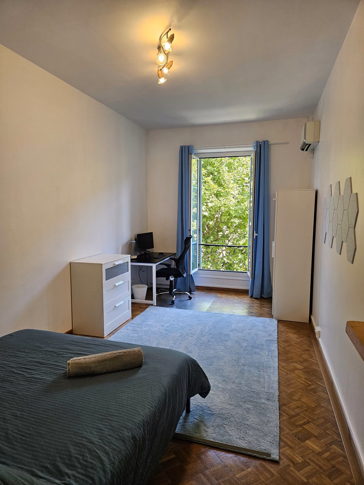 The queen room seen from the bed, with the desk beside the balcony door