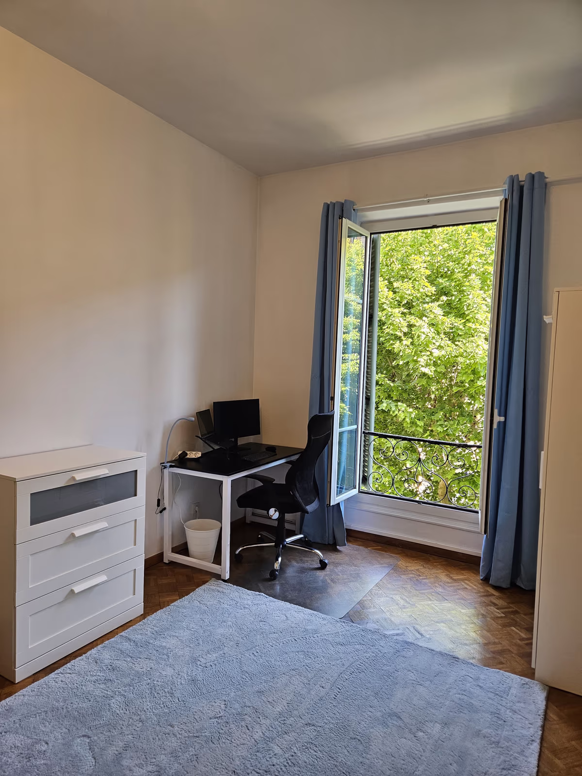 The queen room's chest of drawers and desk beside the open window